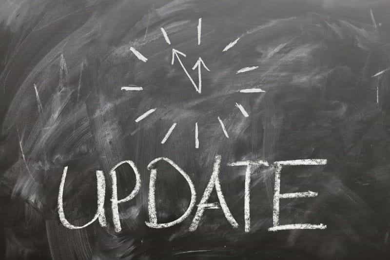 UPDATE under a drawing of a clock is drawn with white chalk on a blackboard.