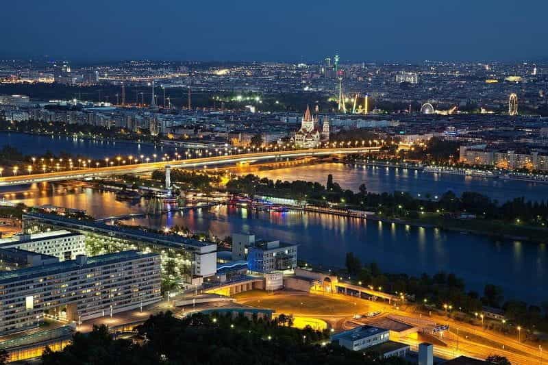 Austria’s capital city of Vienna, with a large bridge in full view along with numerous lit-up buildings and churches.