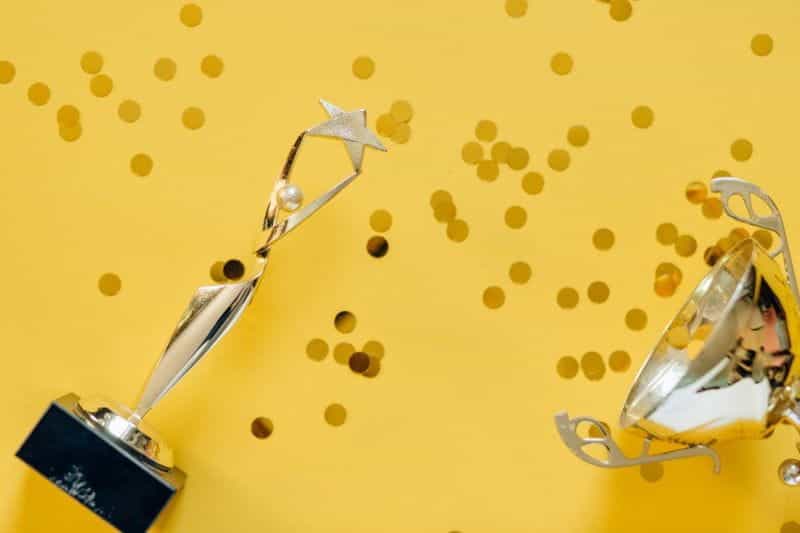Two award trophies with gold confetti.