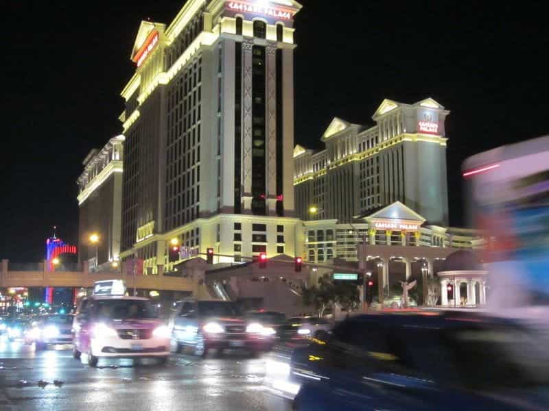 Mobil-mobil bergegas melewati Caesars Palace di Las Vegas Strip pada malam hari.