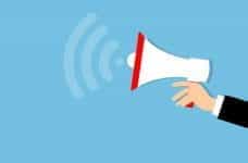 An extended arm holding a megaphone, which is announcing something.