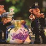 Small figurines policemen confiscating evidence such as laundered money and financial records.