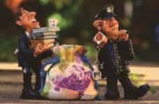 Small figurines policemen confiscating evidence such as laundered money and financial records.