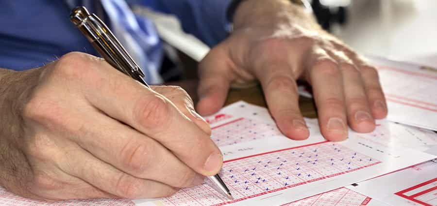 A man filling out a lottery ticket.