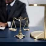 A judge or lawyer working at a desk, with scales of justice.