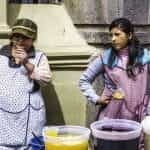 Two women street vendors sell their wares outside in Peru.