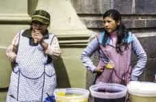 Two women street vendors sell their wares outside in Peru.