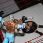 Patung-patung dari dua pejuang WWE berhadapan di atas ring.