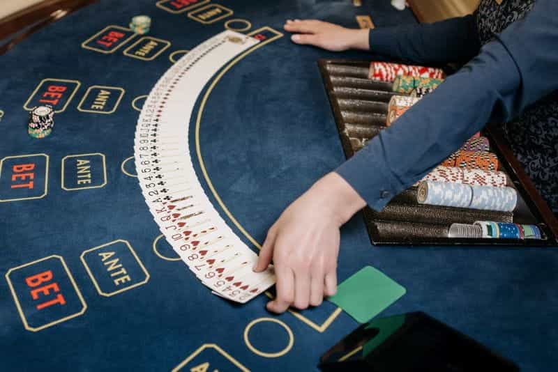 Sebuah bandar kasino live yang menangani setumpuk kartu, dengan chip poker.