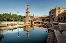 An old building curves around a canal in Sevilla, Spain.