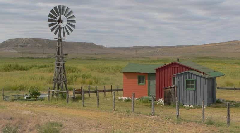 The barren plains of Nebraska, featuring a few small huts and a windmill.