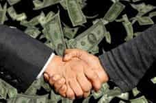 A handshake taking place on a background of flying US Dollar bills.