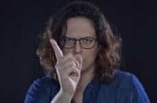 A stern-looking woman wagging her finger in a sign of warning.