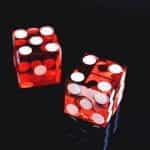 Two red dice with white spots on a black background.