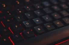 A close-up of a keyboard with red lighting underneath the keys.