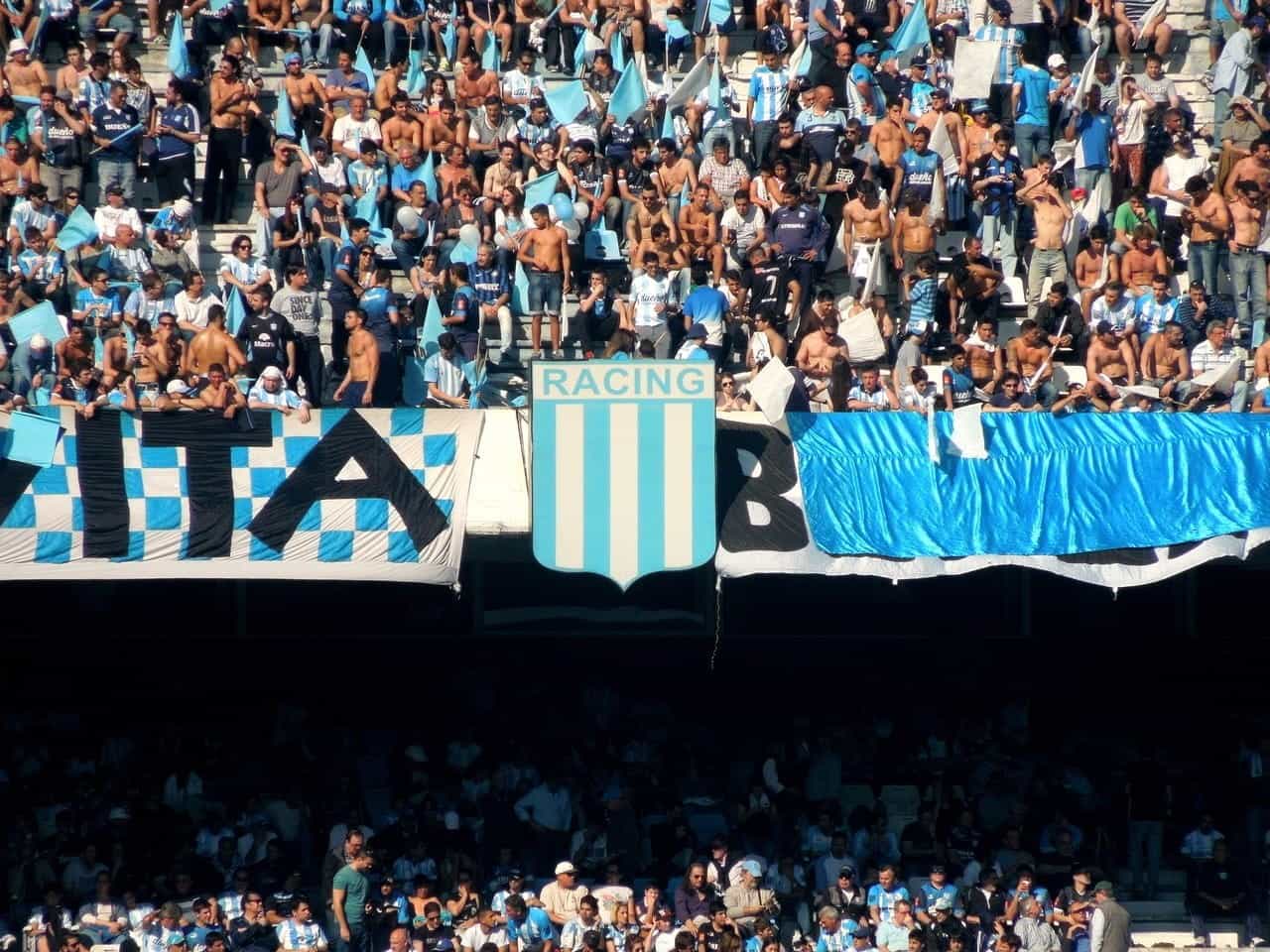 Fans yang mengenakan warna bendera tradisional Argentina memenuhi arena yang ramai untuk menonton pertandingan sepak bola.