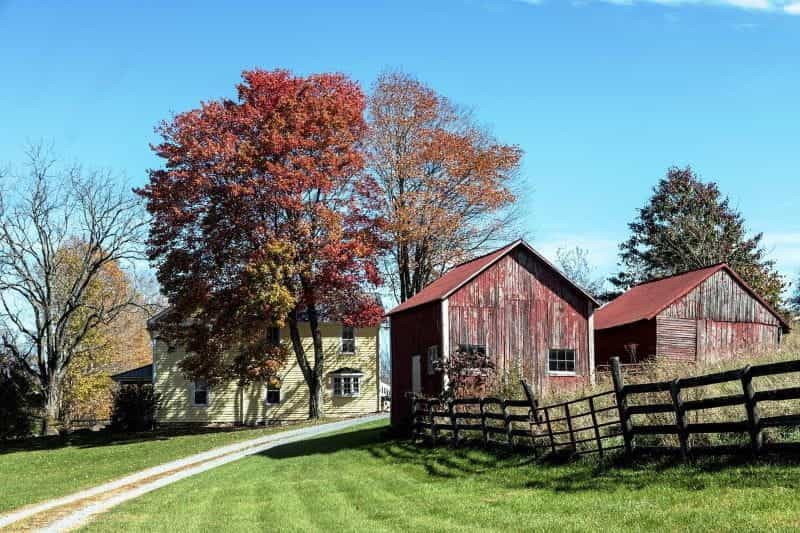 A typical Virginia farmhouse, with two smaller sheds in the foreground.