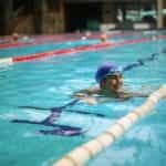 A swimmer wearing goggles and a swimming cap in a swimming pool.