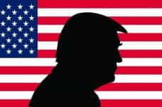 Sillhouette of Donald Trump with an American flag backdrop.