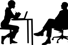 Two silhouetted figures having a meeting with one another at a desk.
