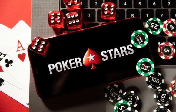 An iPhone displays PokerStars logo with chips and cards placed alongside it.