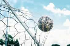 A soccer ball smashes into the goal net.