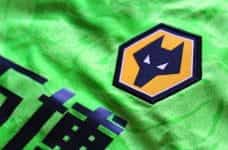 A green football shirt with a Wolverhampton Wanderers logo on it.