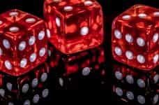 Three red, translucent dice sit on a black background.