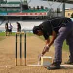 Painting the crease lines in cricket.
