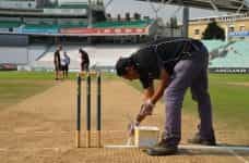 Painting the crease lines in cricket.
