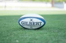 A rugby ball on a grass pitch.