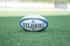 A rugby ball on a grass pitch.