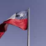 The Chilean flag waves against a dark blue sky.
