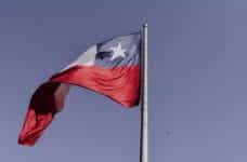 The Chilean flag waves against a dark blue sky.