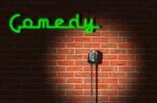 A standing microphone against the brick wall of a late-night comedy club.