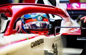 The driver and cockpit of an Alfa Romeo F1 car.