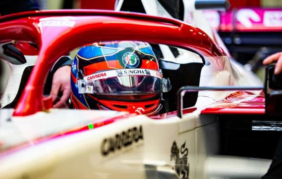 The driver and cockpit of an Alfa Romeo F1 car.