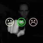 A person selecting a green smiley face in order to indicate positive feedback.