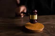 A hand holding a wooden judge's gavel.