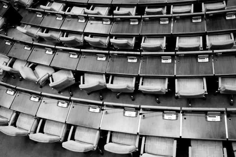 A top-down view of wooden changers in a senate meeting chamber.