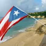 The Puerto Rican flag waves over a beach.