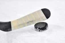 A hockey stick controlling a puck on ice.