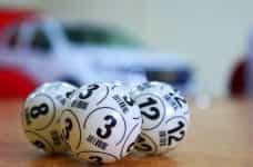 Three bingo balls resting side by side on a table.