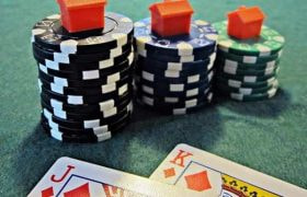 A poker hand, chips and small houses.