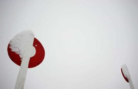 A snow-covered racecourse winning post.