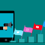 A graphic of a smartphone with an extended arm coming out of it, holding a megaphone directed several flags which feature prominent social media networks’ logos on them.