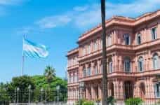 The Argentinian flag waves outside of a grand pink building in Buenos Aires, Argentina.