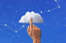 A hand with its index finger raised pointing to a cloud over a background of interconnected nodes.