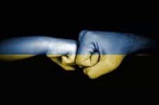 Two hands fist bumping blue at top, yellow at bottom.