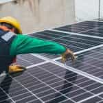 A worker setting up a solar panel.